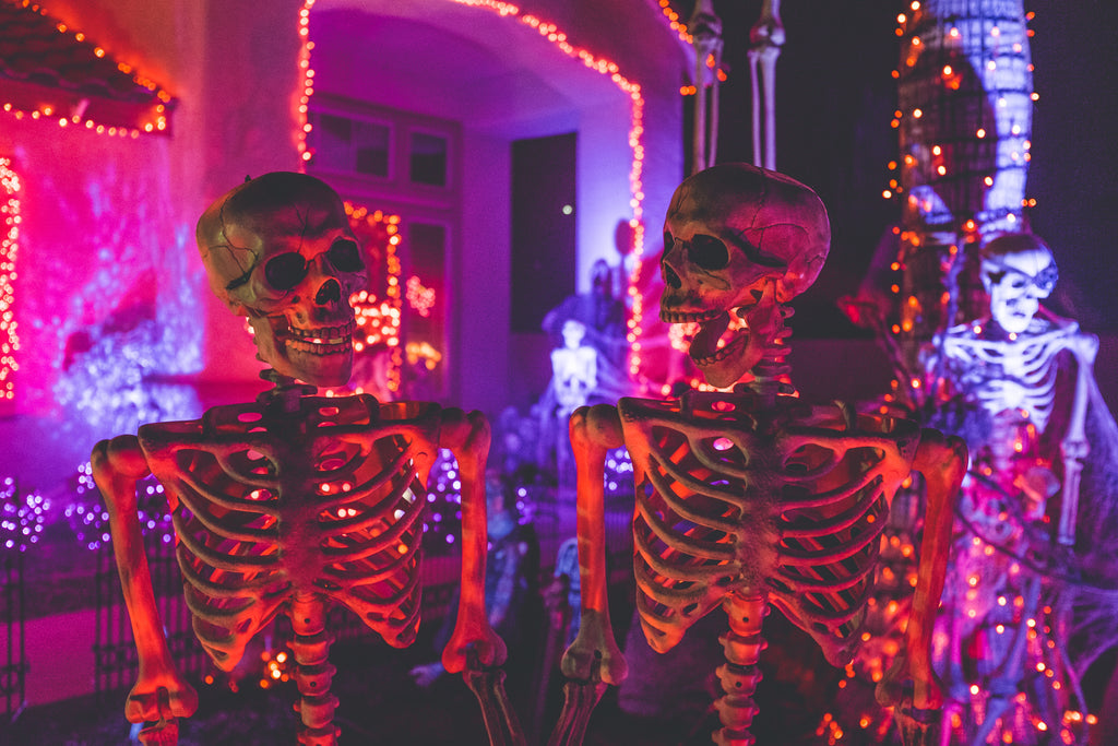 Halloween skeleton decorations in front of highly decorated home